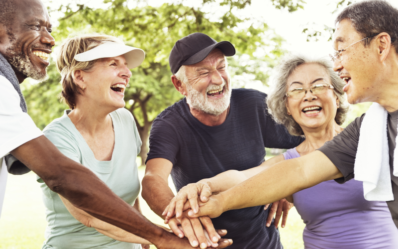 Diverse group of older people with hands together