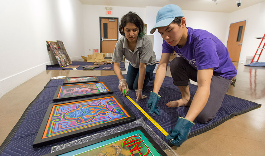 two students measuring items on floor