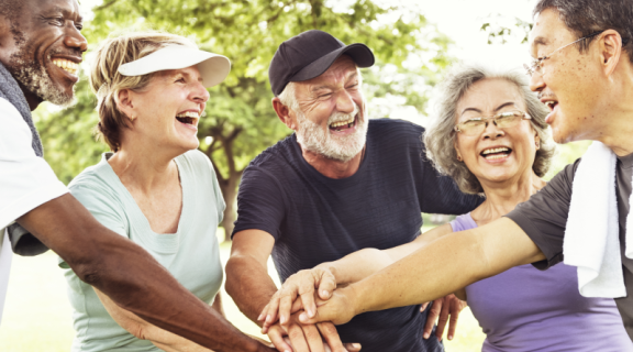Diverse group of older people with hands together
